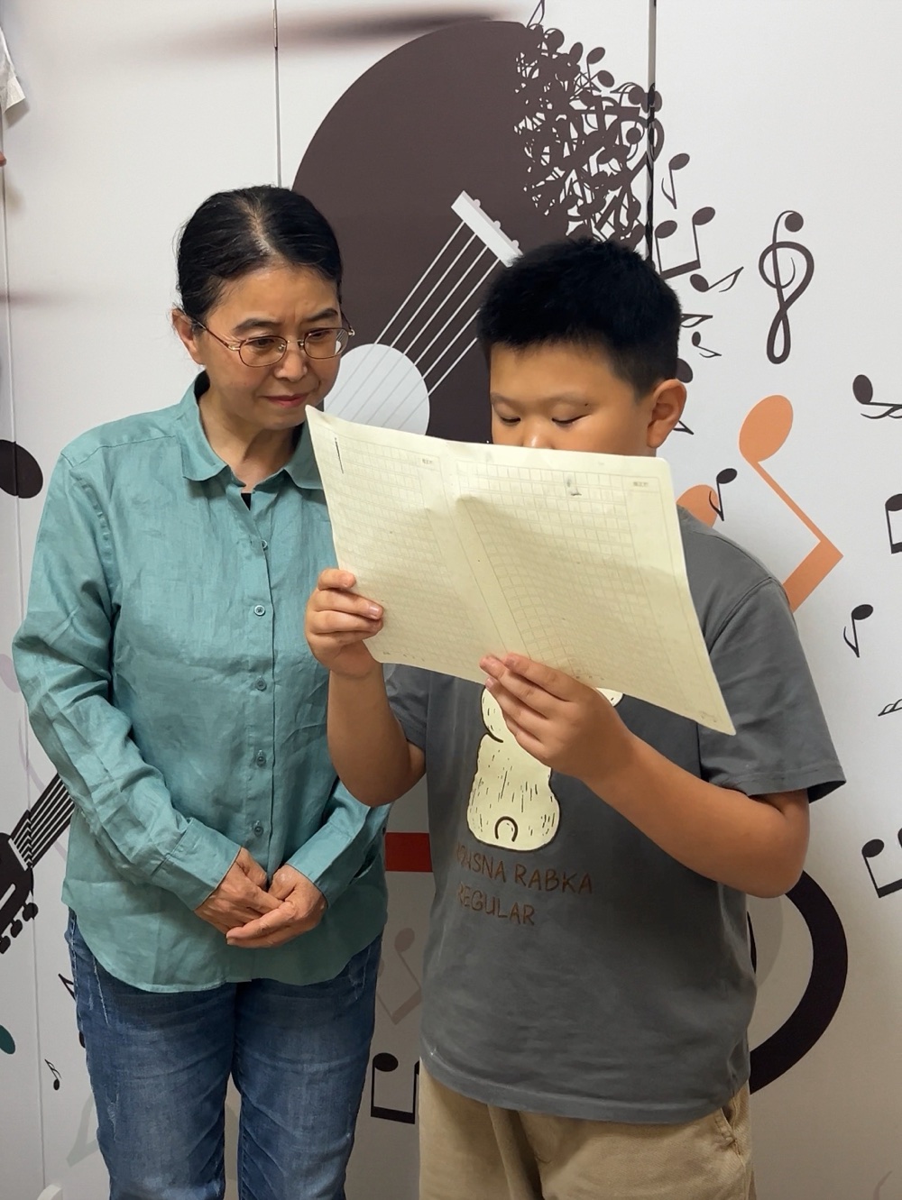 蒙慧老师在孩子朗读习作时认真倾听并给予指导