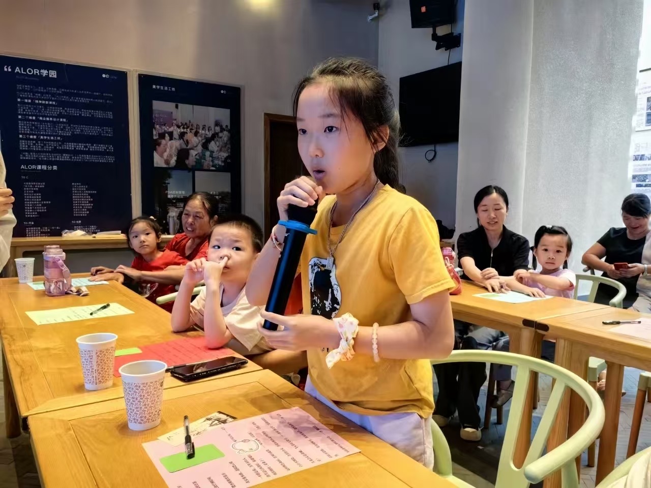 江西公益课堂中一名孩子站立持话筒表达